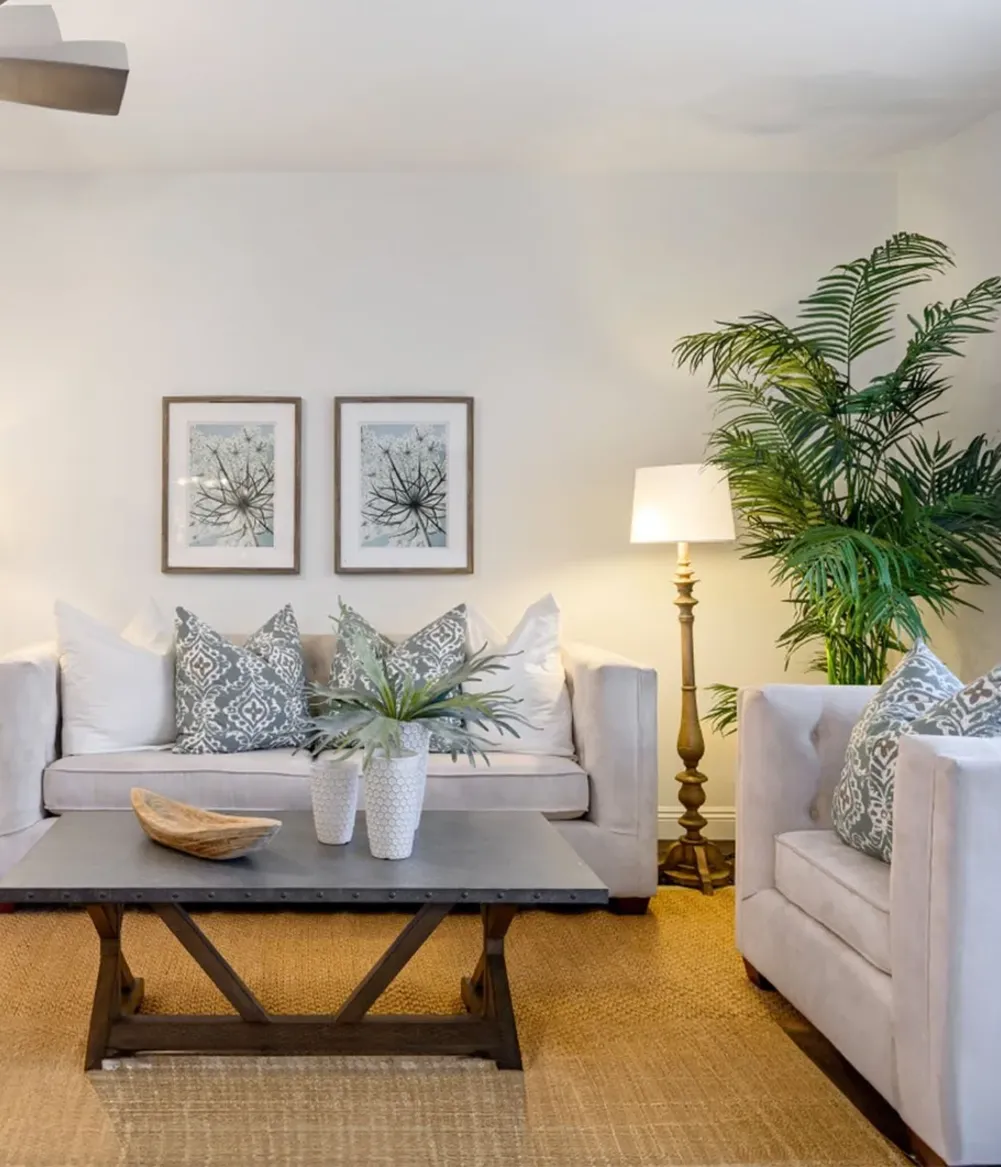 A living room with a tow-seater linen couch and matching arm chair