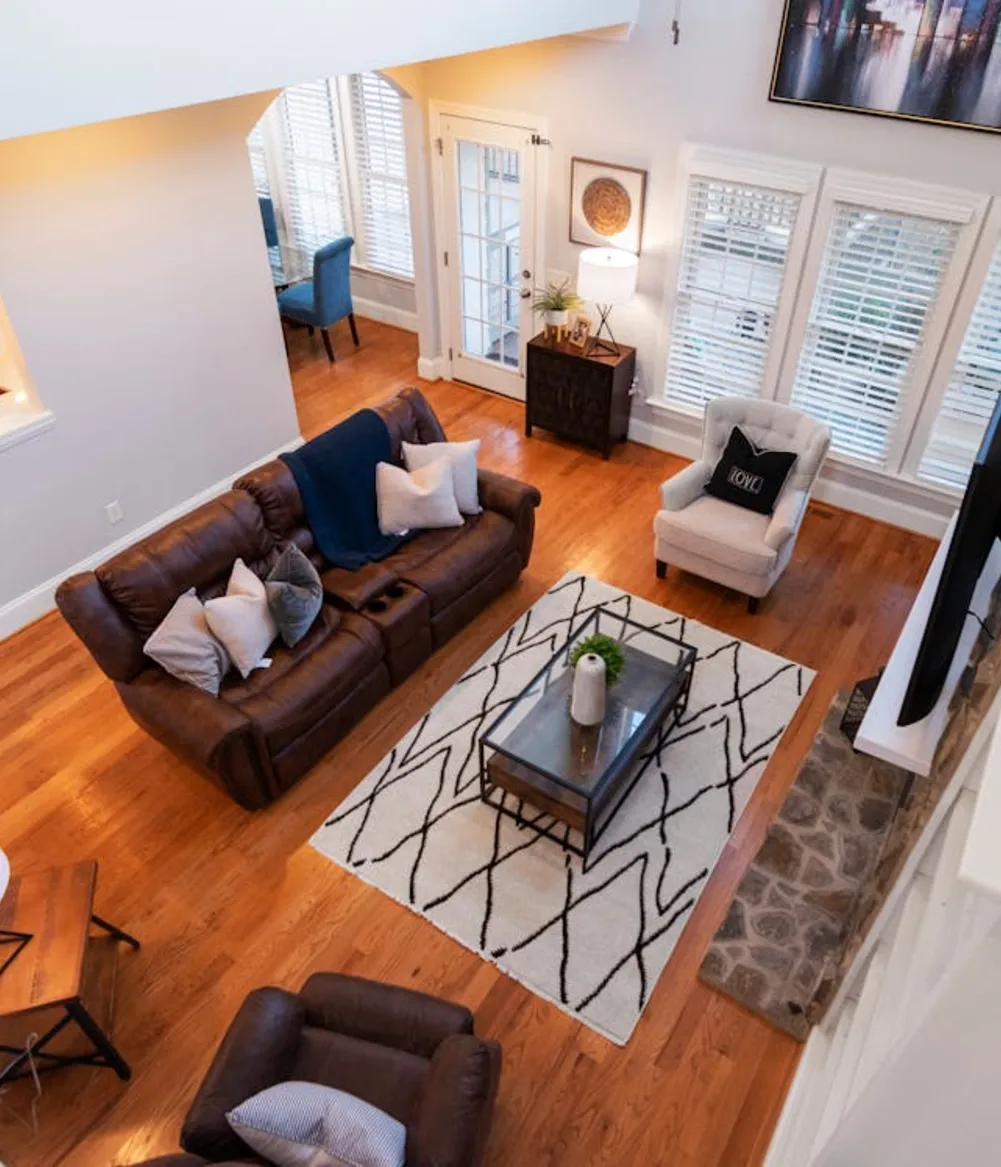a-living-room-with-dark-wood-flooring-and-a-brown-couch A living room with dark wood flooring and a brown couch