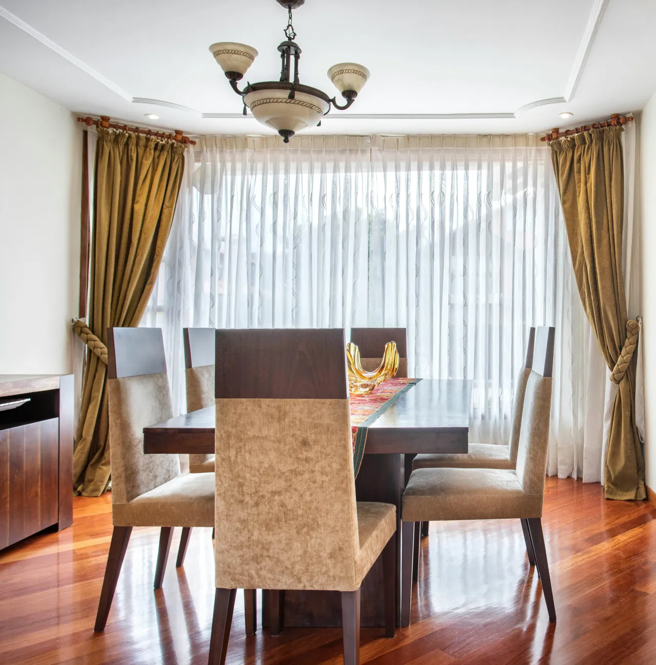 A wooden front door with a dining room off to the side