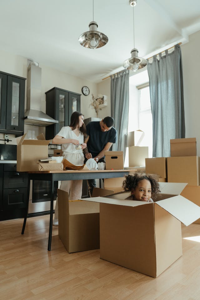 Family unpacking moving boxes together