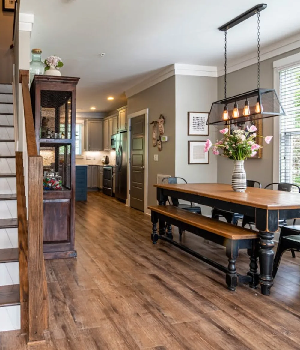 A kitchen and dining areas with dark wood flooring and staircase to the second floor