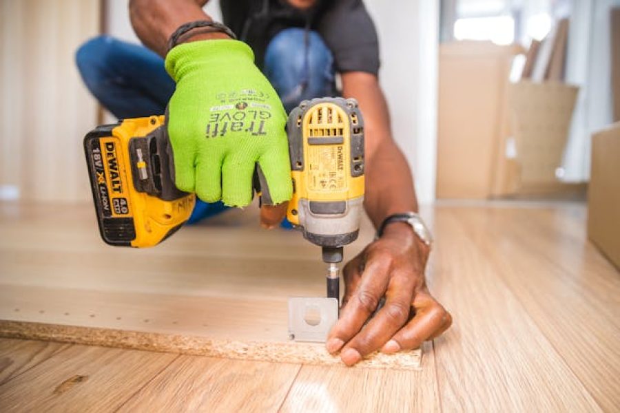 Person using a drill to fix a hinge