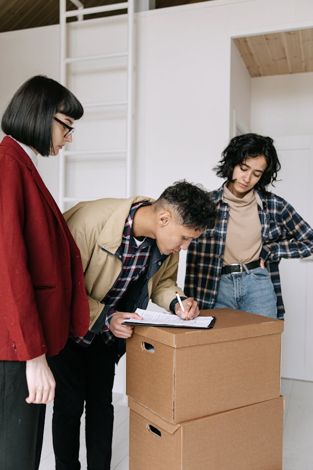 Two tenants signing a lease with a property manager overseeing