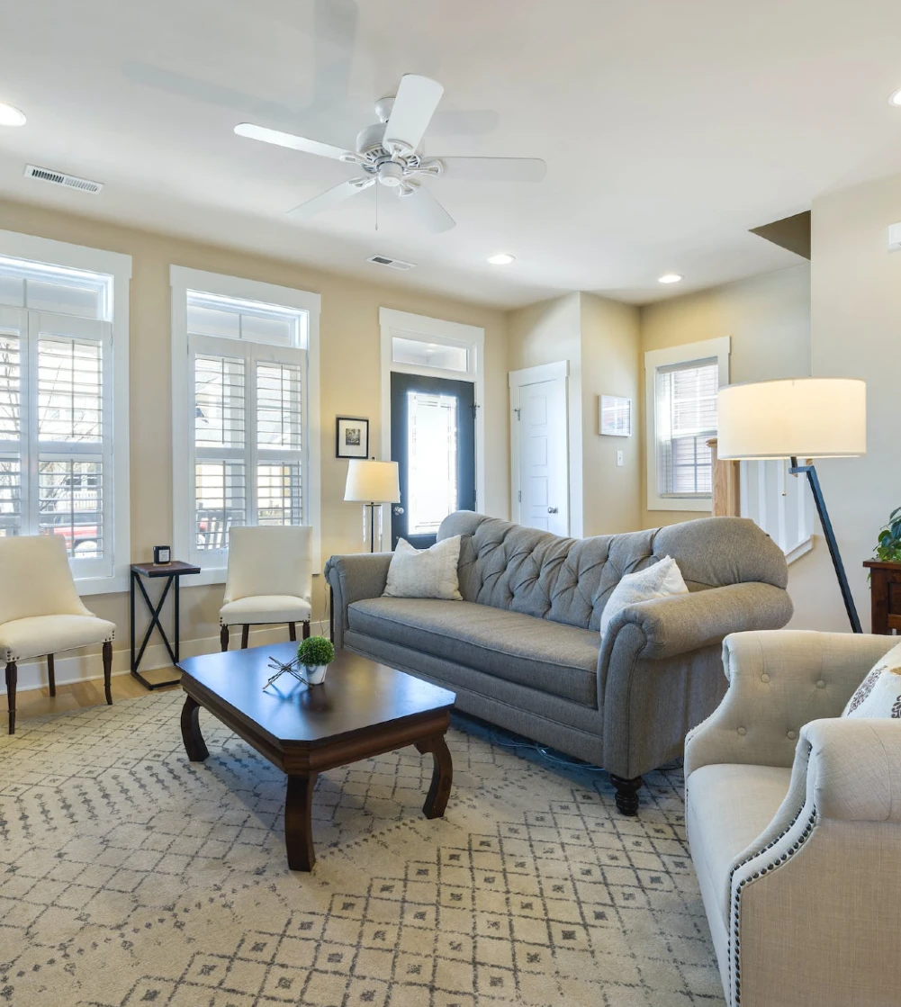 a beige living room with a grey couch and wooden coffee table copy