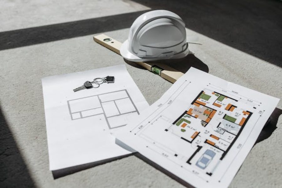 a bunch of home blue prints and a hard hat on the ground