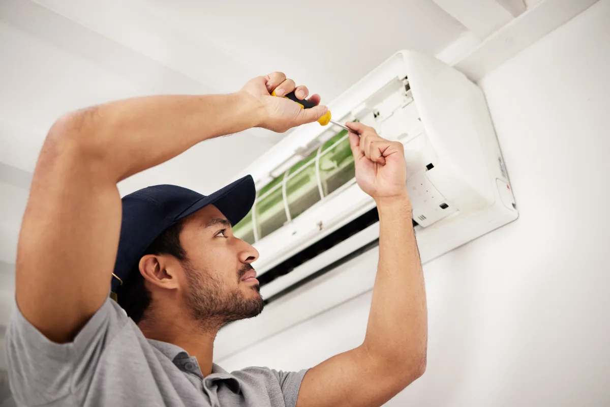 A repairman fixing an air conditioner
