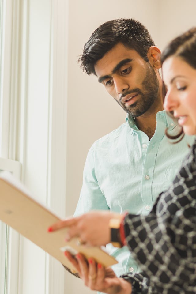 two people looking over a document on a clipboard