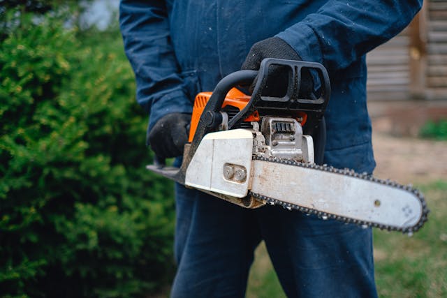 a landscaper holding a chainsaw