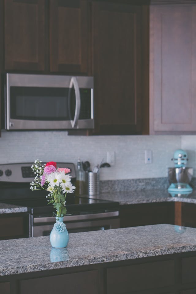 a kitchen with dark cabinets and granite counters