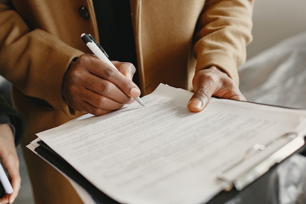 a person looking a lease term and signing a contract
