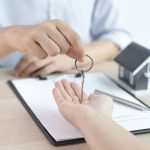 person handing house keys to someone after signing a rental lease