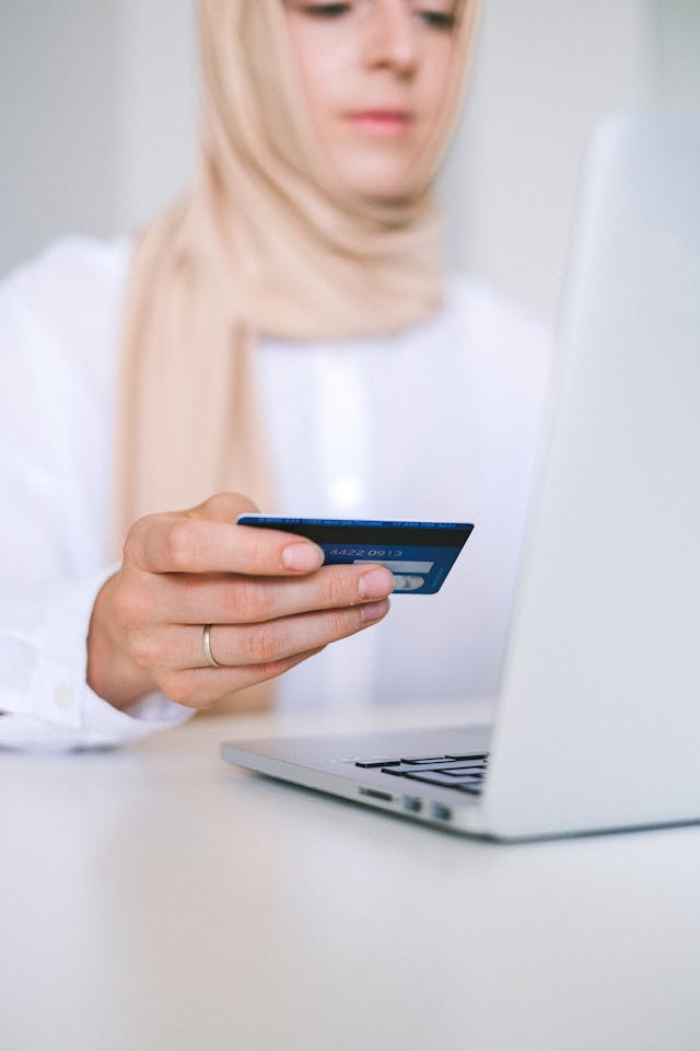 person holding a credit card to make an online payment