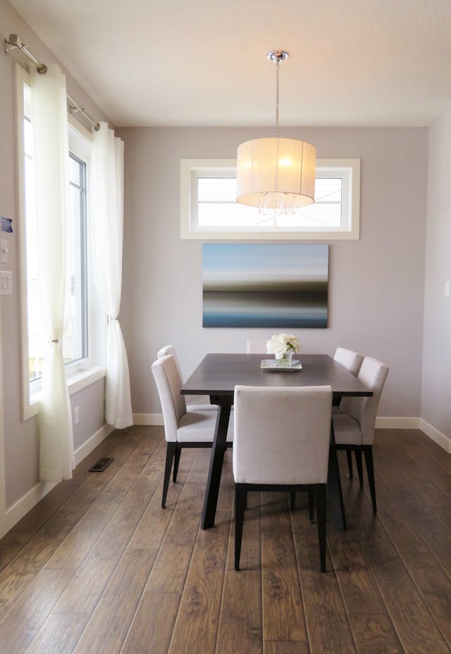a dining room with a dark wood table and beige walls