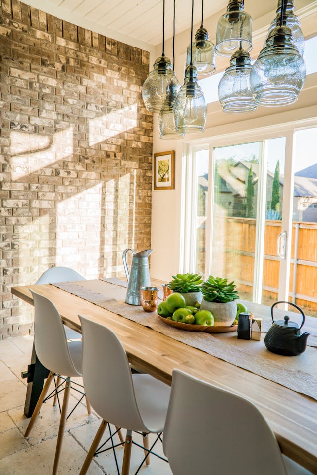 a dining room table with an exposed brick wall in the background