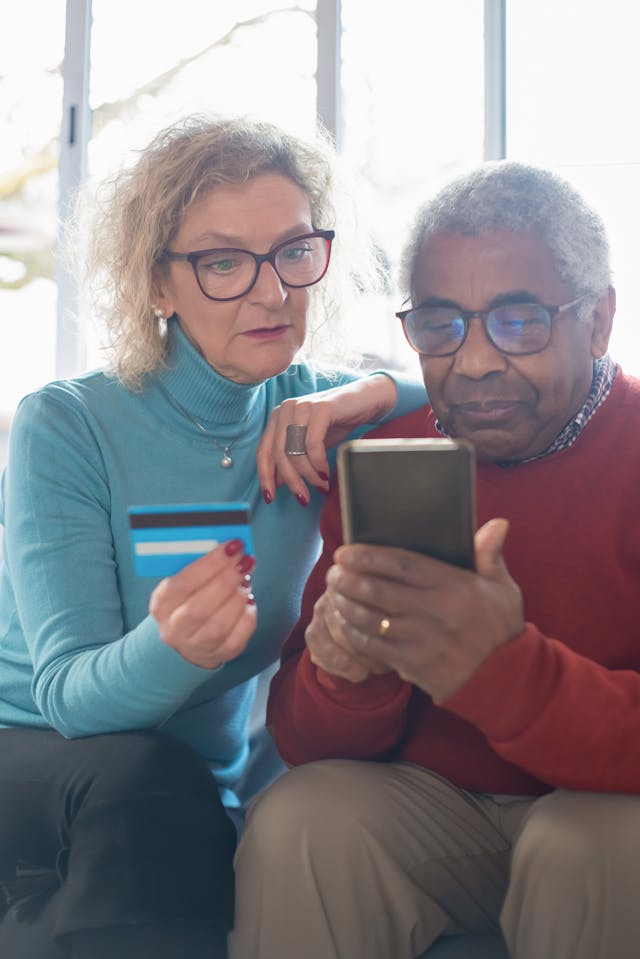 two people making an online purchase with a phone and credit card
