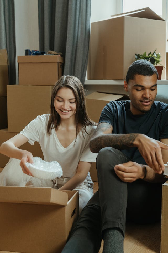two people unpacking moving boxes