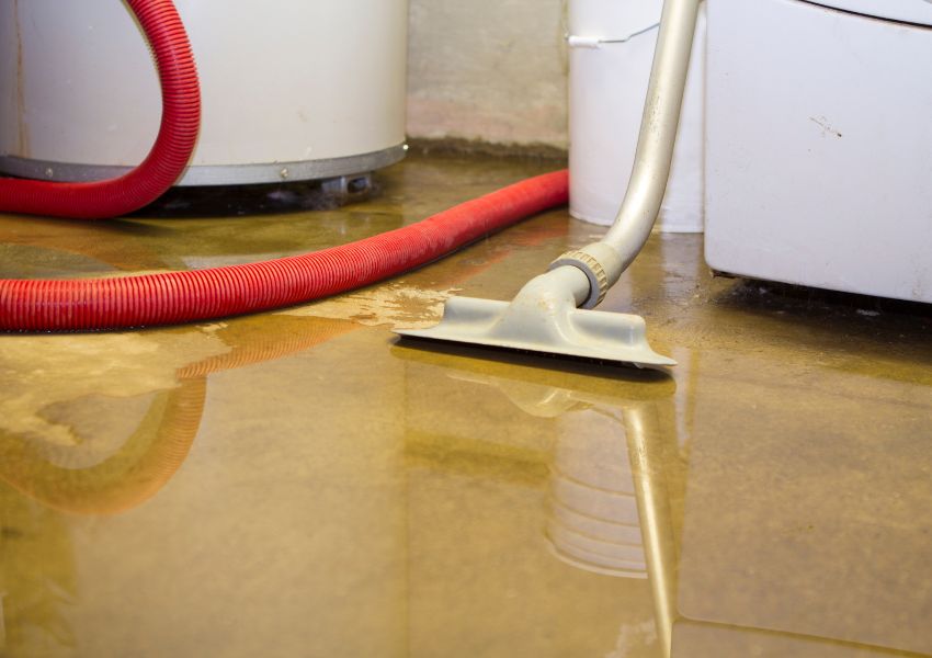 thin layer of water on a basement floor with special water vacuum cleaning it up