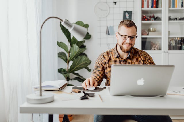 a person sitting at their desk working on their computer