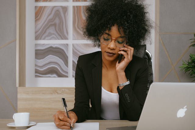 a person sitting at their desk talking on the phone
