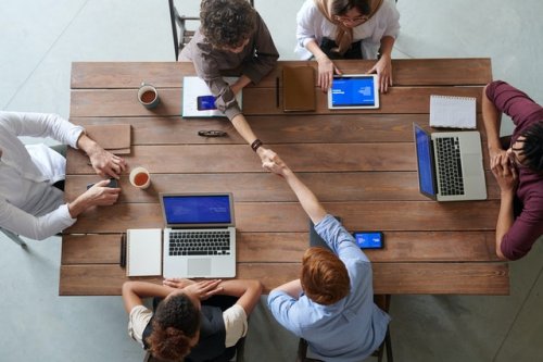 people sitting in a meeting shaking hands